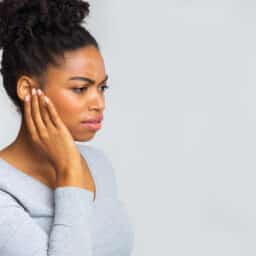 Woman holds ear with earache