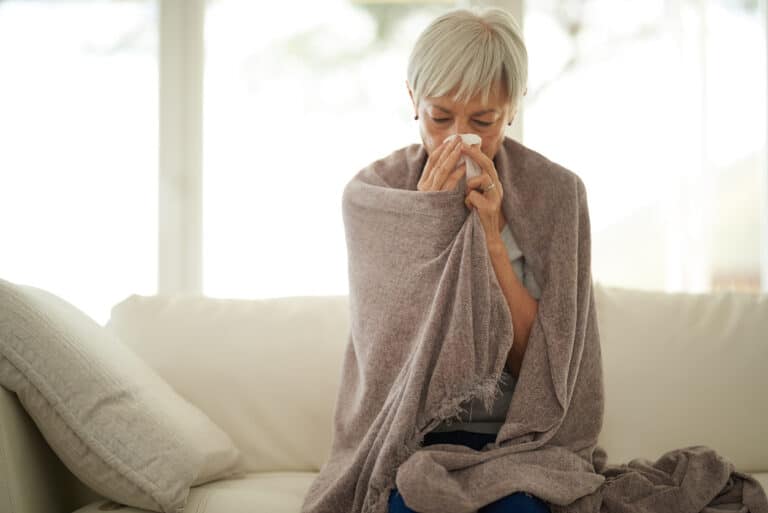 Senior woman blowing her nose