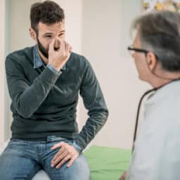 Man discusses nose with doctor