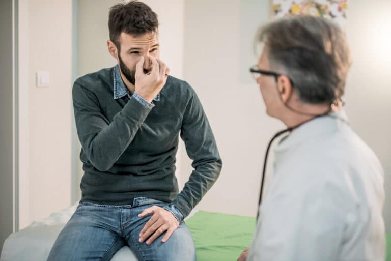 Man discusses nose with doctor
